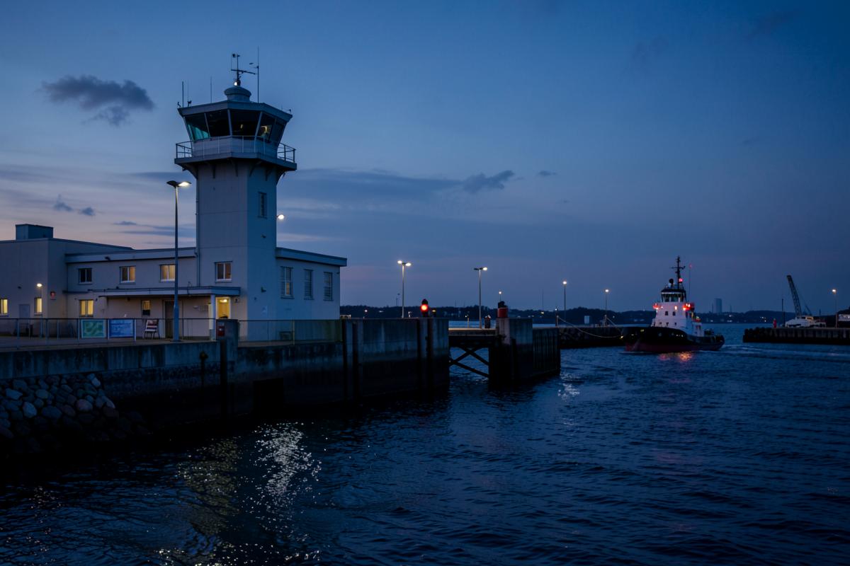 Tour de contrôle portuaire et remorqueur à l'entrée du port au crépuscule